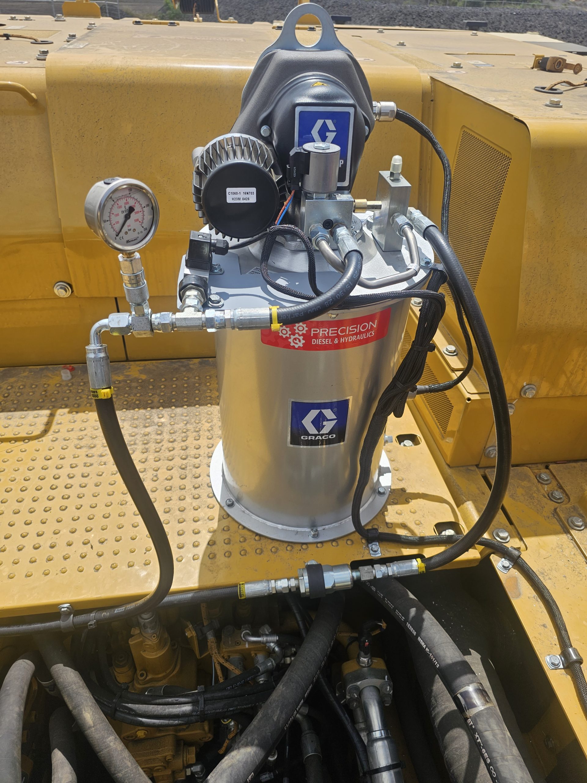 Close-up of a diesel engine featuring a hose and a pressure gauge, highlighting mechanical components and details.